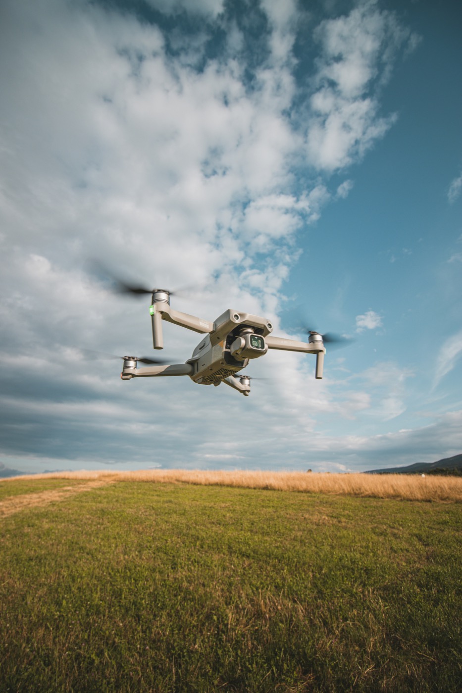 Drone in flight low over a grassy field at golden hour